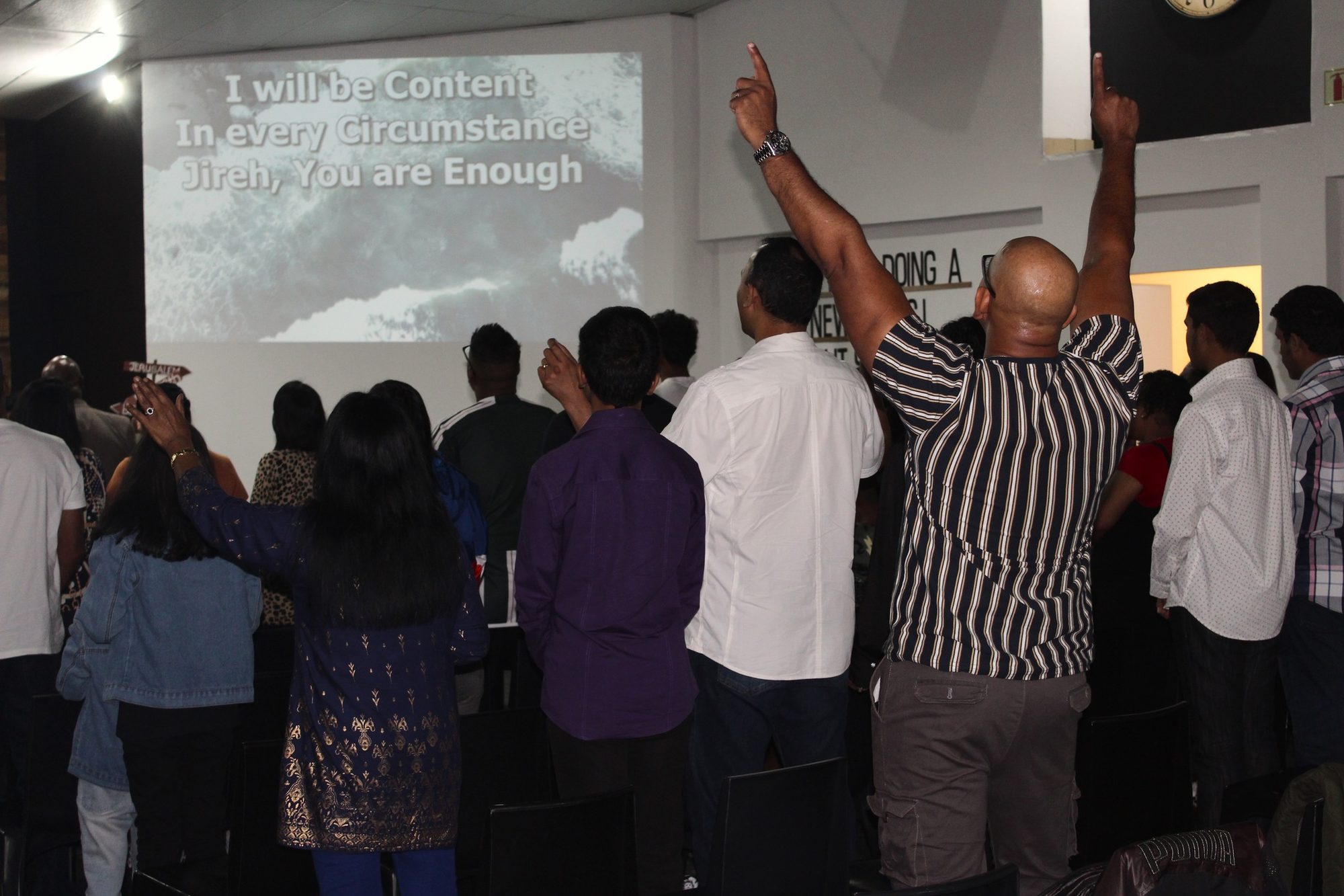 The NewLIFE congregation worshipping with raised hands